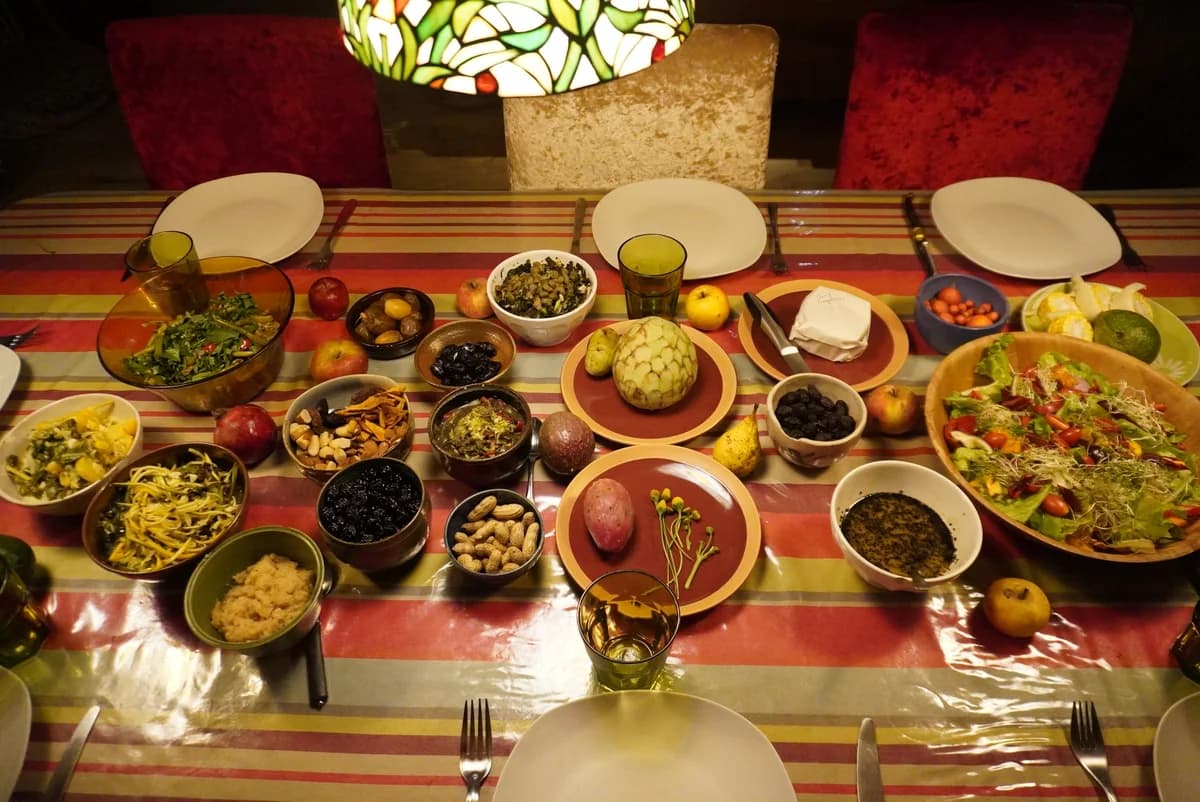 Une table de mezzés : une vingtaine de petits plats, artichaut, salades, sur une nappe rayée