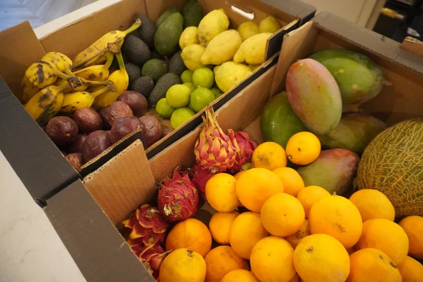 Des cagettes de fruits rares : mangues, pitayas, fruits de la passion, citrons et avocats